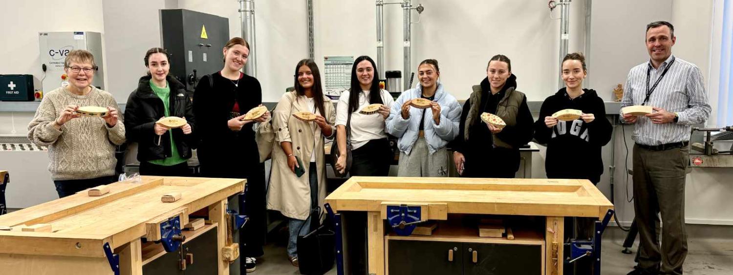 Students show off their wooden boats as part of the program